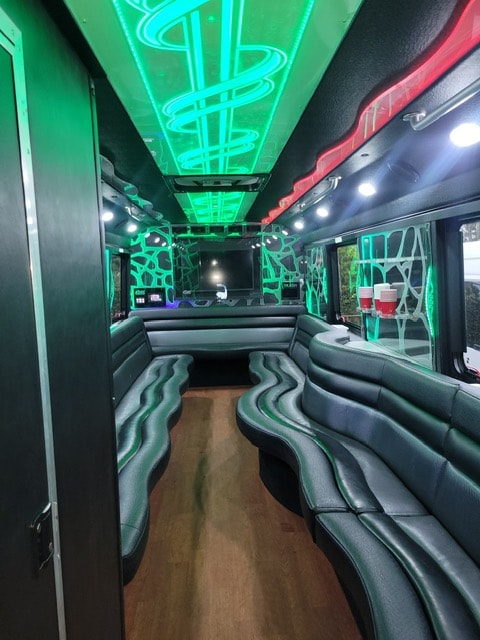 26-passenger party bus interior with green neon lighting