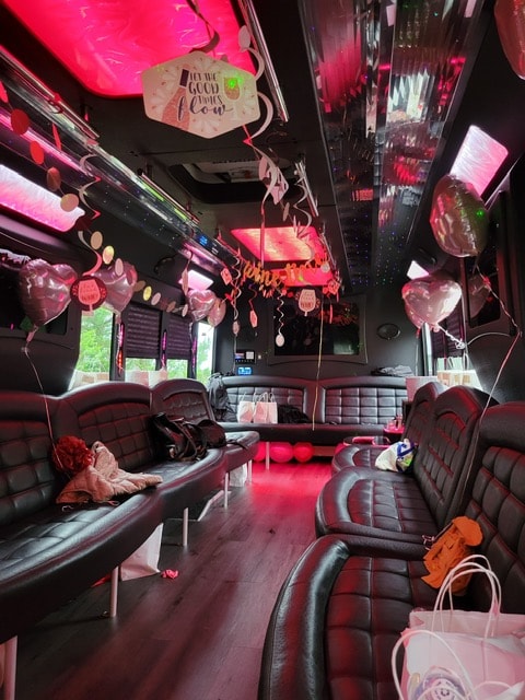 32-passenger bus interior decorated with pink balloons and neon lighting