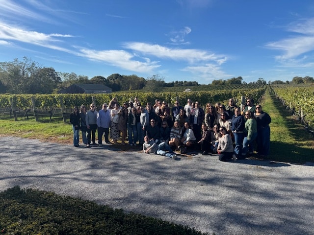 Large corporate group photo at North Fork vineyard