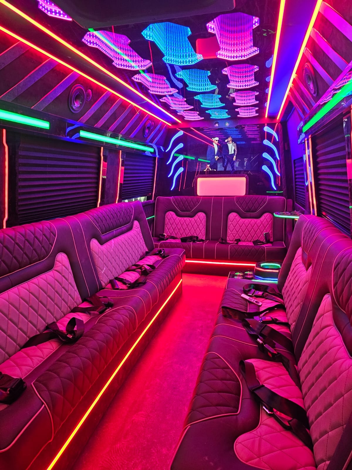 18-passenger party bus interior with vibrant pink and neon lighting